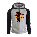 Sweat à capuche gris clair avec manches navy et silhouette de Goku enfant devant une lune orange ornée d'étoiles, inspiré de l'univers Dragon Ball, parfait pour un look casual et geek.

