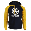 Sweat à capuche bicolore avec un corps noir et des manches jaunes vives, affichant un logo blanc Capsule Corp centré sur le devant. Ce hoodie moderne dispose de cordons assortis jaunes et d'une poche kangourou pratique, parfait pour les fans de culture geek et d'habillement casual.