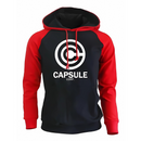 Sweat à capuche bicolore avec un corps noir et des manches rouges vibrantes. Le devant arbore fièrement le logo blanc Capsule Corp. Le hoodie est équipé d'une poche kangourou pratique et de cordons rouges assortis pour un style tendance, idéal pour les amateurs de mode geek et casual.