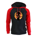 Sweat à capuche noir avec manches rouges et silhouette de Goku enfant devant une lune orange ornée d'étoiles, inspiré de l'univers Dragon Ball, parfait pour un look dynamique et geek.