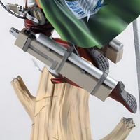 Détail de l'équipement de manœuvre tridimensionnel de Levi sur sa figurine, incluant les bottes, les lames et le harnais attaché à un tronc d'arbre